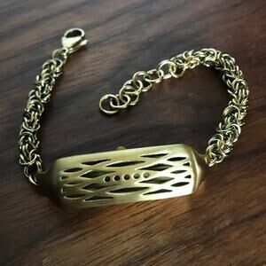 Brushed gold tone bracelet w/ a compartment for a fitbit device